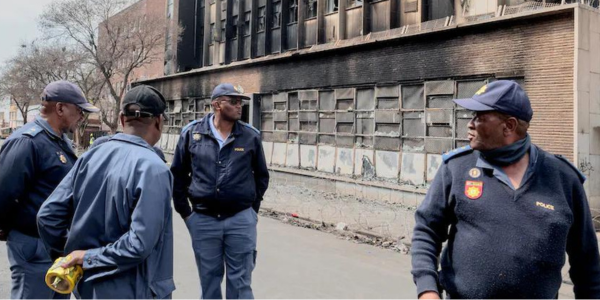 South African police officers at the scene of the burned building in Johannesburg. Luca Sola/AFP via Getty Images